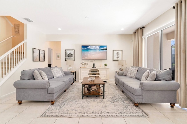 Bright and inviting living room with access to the kitchen and dining rooms and the private pool