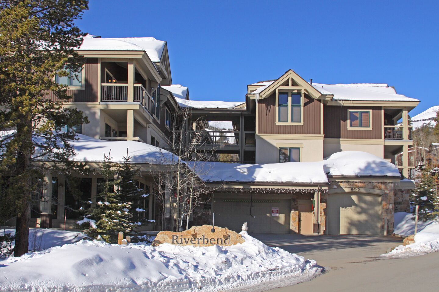 A multi-story hotel with a covered entrance and snow-covered roofs.