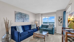 A living room with two sofas, a coffee table, and a view of the ocean. - Completely Renovated Oceanfront Unit in Quaint Surfside Beach! SC205b (Surfside Beach)