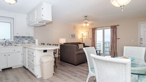 Een compacte woonruimte met kitchenette, eethoek en balkon.