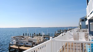 A boat docked at a pier with a clear view of the water and distant land. - Unique, stylish 4 bedroom bayside townhouse with free WiFi, pier boat docking, and a breathtaking view of the ocean located midtown on the bay water and just a few blocks from the beach! (Ocean City)