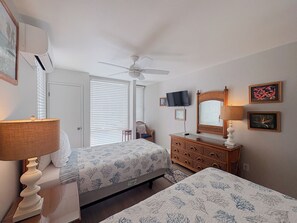 A bedroom with two beds, a dresser, a television, and a ceiling fan. - Hale Kamaole 245  Second floor condo, easy access to best beach on Maui! (Kihei)