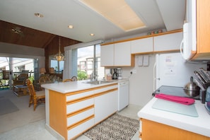 Une cuisine moderne dotée d’un îlot central, de meubles en bois et d’un four encastré.