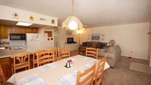 Un espacio habitable compacto con comedor, cocina y zona de estar.