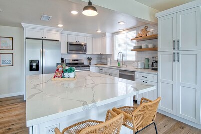 Experience coastal living at its finest in this spacious upstairs unit just steps from the sand!