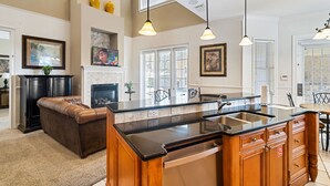 A spacious kitchen with a large island, wooden cabinets, and pendant lighting. - Homestead Holly: Game Loft, Private Pool, Water Park, Near Disney (Kissimmee)