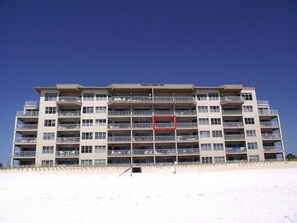 Ein mehrstöckiges Hotel mit Balkonen direkt am Strand.