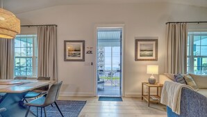 Un salón moderno con comedor, un sofá, una lámpara y vistas al balcón exterior.