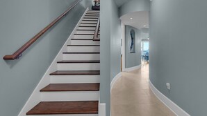 A staircase with wooden steps and a handrail, leading to a landing with a lamp and a framed picture. - Penthouse, Private Master Balcony, Gulf and Dune Lake Views (Santa Rosa Beach)