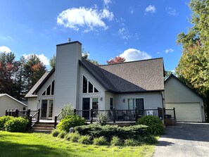 A two-story house with a chimney, large windows, and a garage. - Berry Bear Depot @ Spring Brook Resort (Wisconsin Dells)