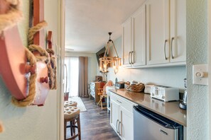 Enjoy meals in this kitchen with a dishwasher, toaster, and ample countertop space, connected to a dining area with a table and chairs.