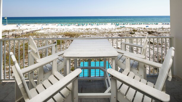 A beach view from a balcony with a table and chairs, overlooking the beach and ocean. - GD 307: Seaglass Cove - Step Out, Chill Out... Beachfront Living at Its Best! (Fort Walton Beach)