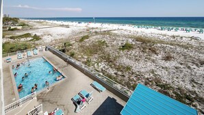A pool area with lounge chairs and a view of the beach. - GD 307: Seaglass Cove - Step Out, Chill Out... Beachfront Living at Its Best! (Fort Walton Beach)