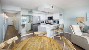 A modern kitchen with white cabinets, a stainless steel refrigerator, and a microwave. - GD 307: Seaglass Cove - Step Out, Chill Out... Beachfront Living at Its Best! (Fort Walton Beach)