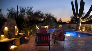 Une terrasse extérieure avec une piscine, des sièges et des cactus.