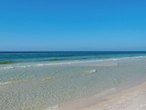 Uma praia com águas cristalinas e uma extensa faixa de areia.