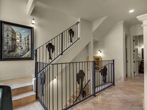 Stunning staircase leads to an upper floor, flanked by a beautiful painting and elegant tilework.