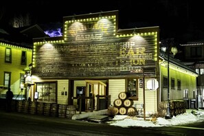 A building with a marquee sign, a storefront, and stacked barrels outside.