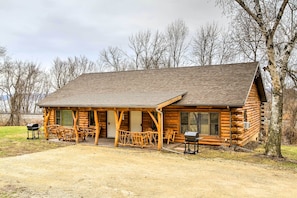 A log cabin with a porch, outdoor seating, and a grill area. - Cabin Near River - Treehouse Masters Stayed Here! (Ferryville)