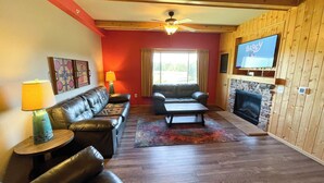 A living room with a fireplace, leather sofas, a coffee table, and a television. - Three Bedroom Condo @ Spring Brook Resort (Wisconsin Dells)