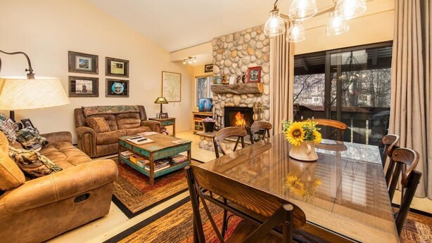 Una sala de estar acogedora con chimenea, una mesa de comedor y asientos cómodos.