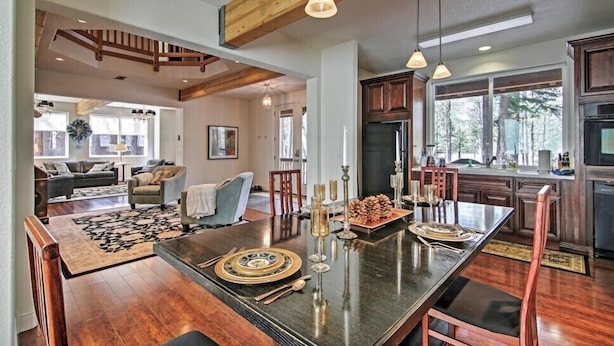 A spacious living area with a large dining table, wooden beams, and a kitchen with dark cabinets and a refrigerator. - 1 Mi to Mtn, 1 More to Shore! Luxury Tahoe Home (South Lake Tahoe)