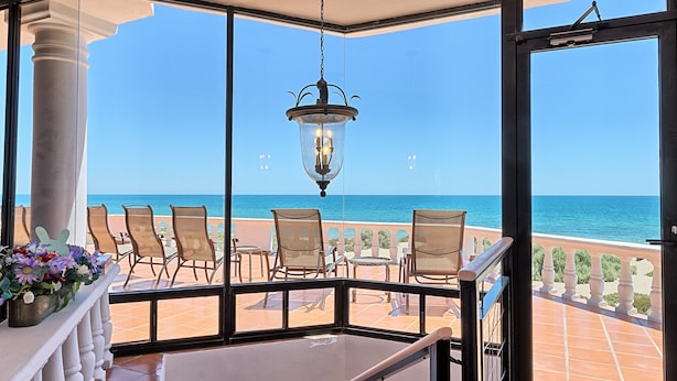 A terrace with a view of the sea, furnished with chairs and a table, and a staircase leading to an upper level. - Whale of a Tale – Adults-Only Beachfront (Puerto Peñasco)