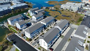 Un complexe hôtelier situé sur la côte, composé de plusieurs bâtiments, doté d’un port de plaisance et offrant une vue sur l’océan.