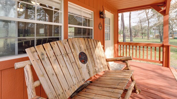 A wooden bench on a porch with a view of a park and trees. - Plantersville Cabin on 50 Acres w/ Pond & Fire Pit (Plantersville)