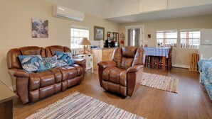 A spacious living area with leather sofas, a dining table, and a kitchen in the background. - Plantersville Cabin on 50 Acres w/ Pond & Fire Pit (Plantersville)