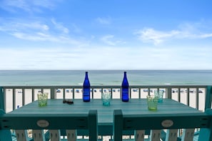 Une terrasse en bois offrant une vue sur la plage et l’océan.