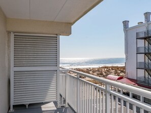 Un balcon avec vue sur la plage et l’océan.