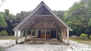 Ein hölzerner Pavillon mit einem Dreiecksdach und einer überdachten Sitzgelegenheit.