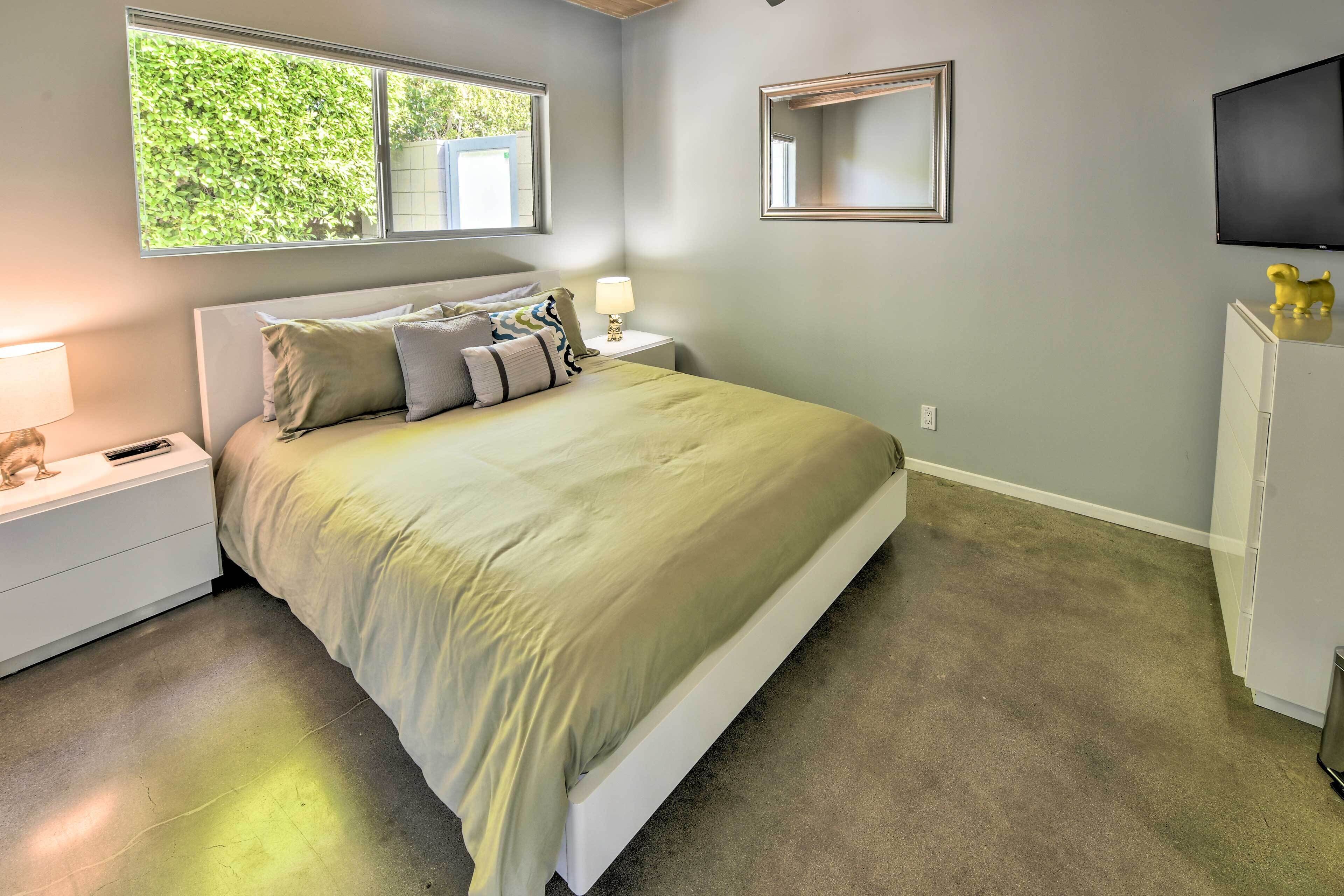 A bedroom with a bed, nightstands, a TV, and a wardrobe.