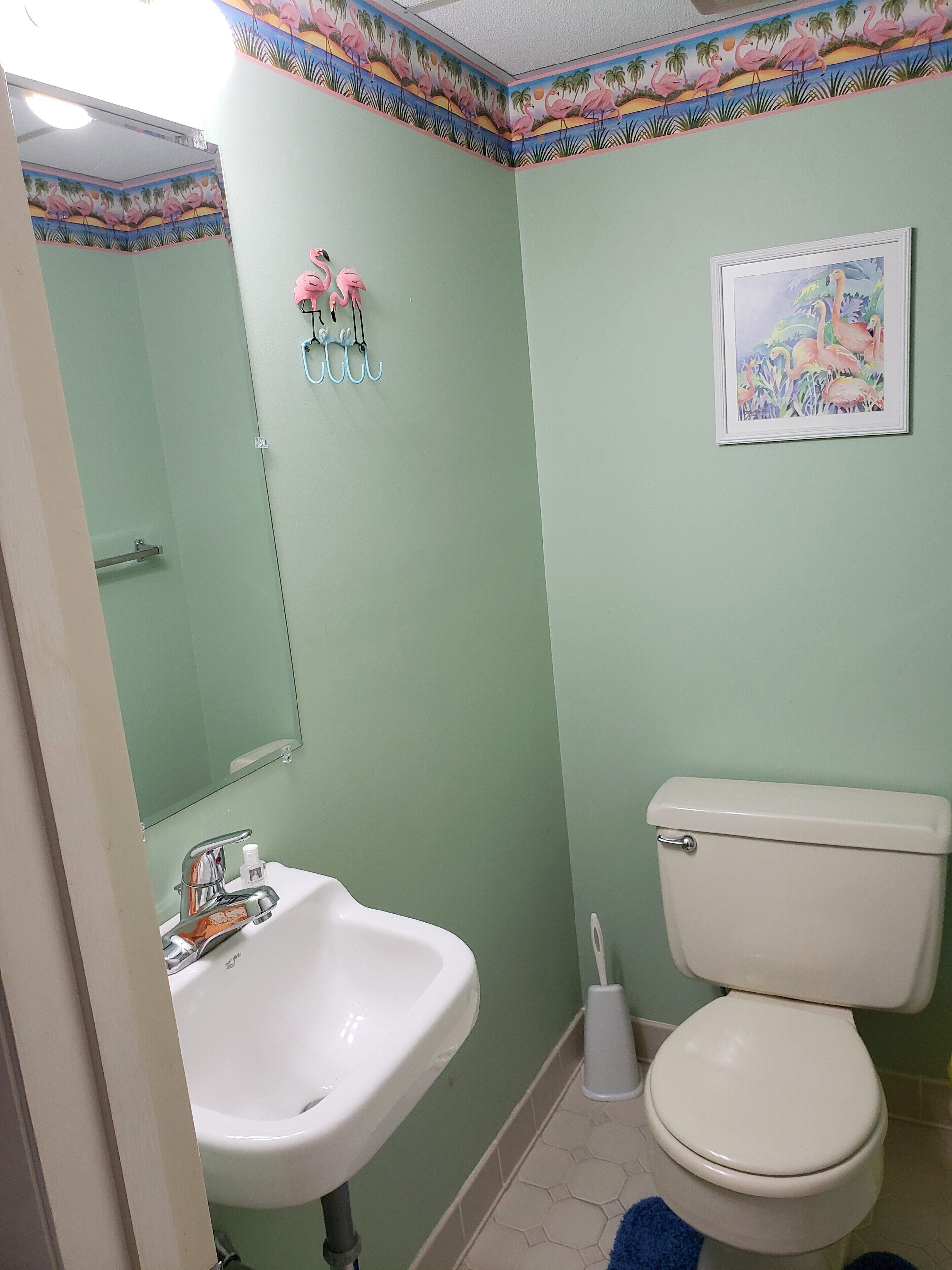 Une salle de bain avec des toilettes, un lavabo et un miroir.