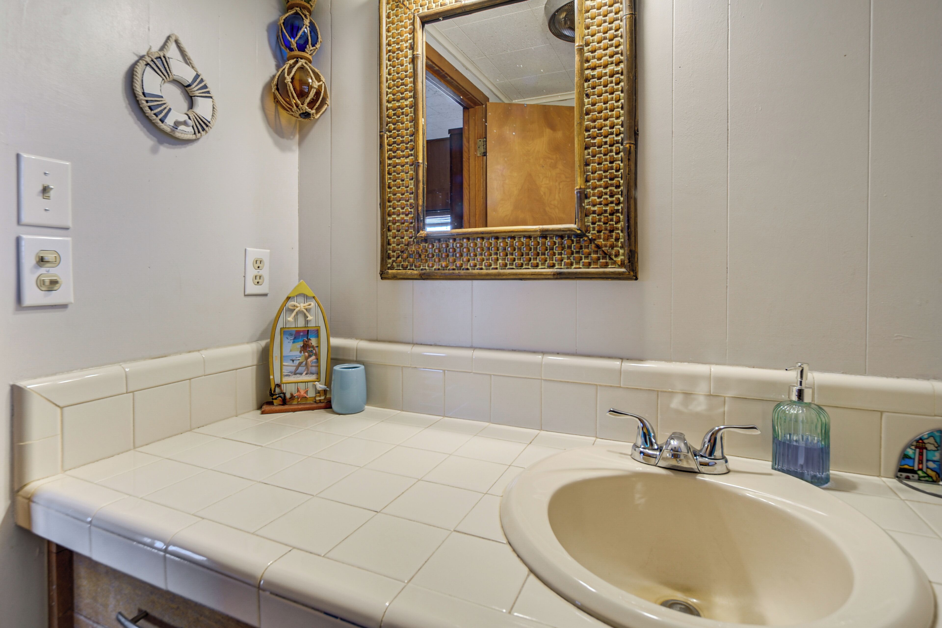 A bathroom with a large mirror, a sink, and a toilet.