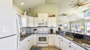 A kitchen with white cabinets, a microwave, an oven, and a sink. - WH816- Remarkable! 6 BRs, Private Pool, Hot Tub and even a Volleyball Court! (Corolla)