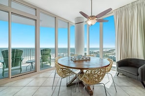 Enjoy the city and ocean views from this balcony with a round table and comfortable seating.