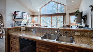 A spacious kitchen with granite countertops, a double sink, and wooden cabinets. - Quick Walk to Main St Breckenridge! Outdoor Hot Tubs/Pool! Attached Garage, Slee (Breckenridge)