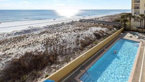 A pool adjacent to a beach with a wooden walkway leading to the shore. - PI 311: Ocean’s Embrace - Amazing! Granite, 4Led Tvs, Reserved Parking (Fort Walton Beach)