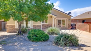 A residential house with a brick exterior, a large tree, and landscaped garden with various plants. - Family-Friendly Utah Home, Easy Access to Zion! (La Verkin)
