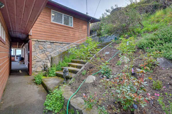 Uma casa de madeira com uma escadaria de pedra que dá para um alpendre.