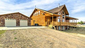 A two-story wooden house with a front porch, a garage, and a deck. - Rustic Bryce Canyon Home w/ Deck on Sevier River! (Hatch)