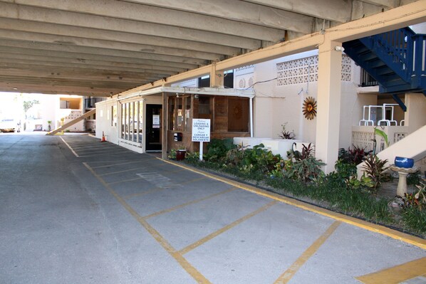 A parking area with a covered walkway leading to a building entrance. - Suntide II 403 - Breathtaking Ocean Views from Condo, Luxurious Grounds, Direct Beach Access (South Padre Island)