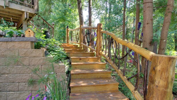A wooden staircase with a wooden railing leading up to a wooden deck. - Lakefront Deer River Apt w/ Dock, Fire Pit & Patio (Deer River)