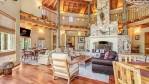 A spacious living area with a fireplace, wooden furniture, and a stone accent wall.
