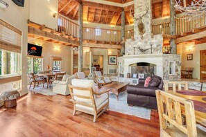 A spacious living area with a fireplace, wooden furniture, and a stone accent wall.