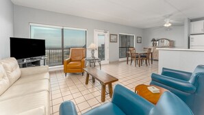 A spacious living area with a sofa, armchairs, a coffee table, and a television. - Saida I 602 - Beachfront Condo, Private Balcony, Tennis Courts, Oceanfront Swimming Pools, Hot Tubs (South Padre Island)