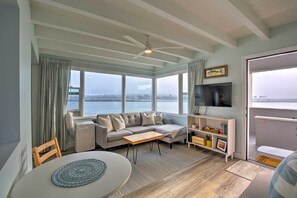 Enjoy the stunning view of the water and cityscape from this spacious living room with a comfortable sofa set and large window.