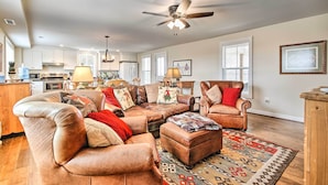 A spacious living room with a large sectional sofa, a leather armchair, and a patterned rug. - 'Anny's Farm House' Near Middleburg & Wineries! (Round Hill)